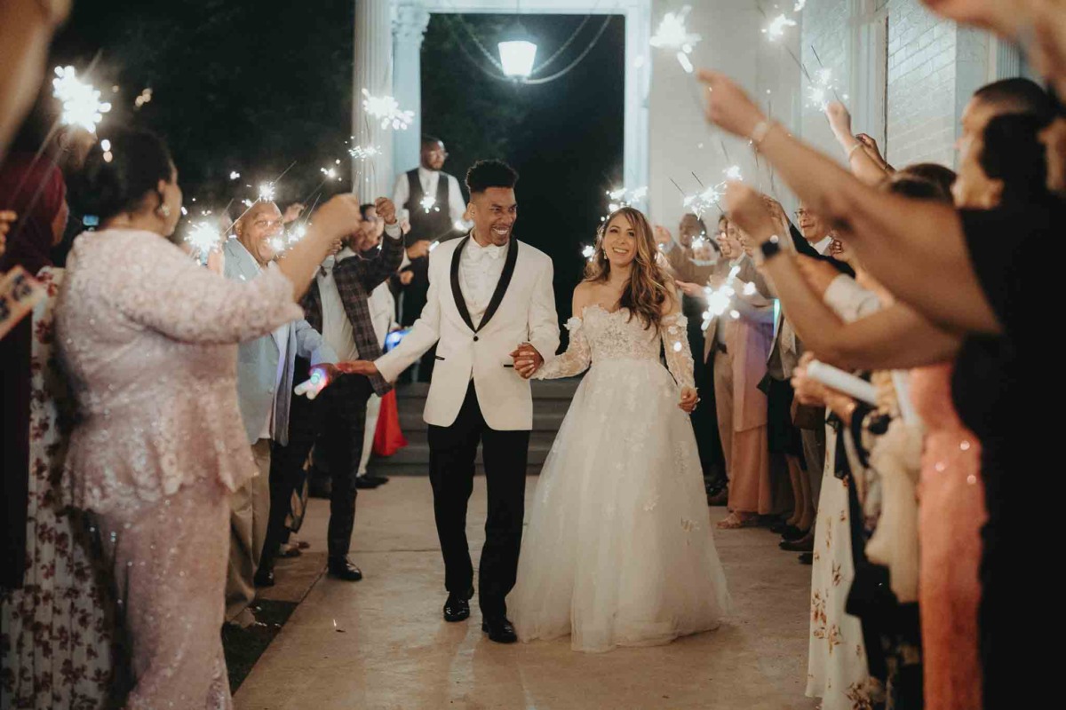Couple exits wedding amidst sparklers.